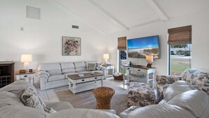 A living room with a sofa, a coffee table, and a TV.