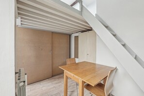 Een kamer met een houten tafel, een stoel en een schuifdeur.