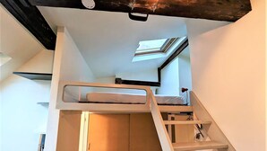 Ein kleines Zimmer mit Etagenbett, Oberlicht und Kleiderschrank.