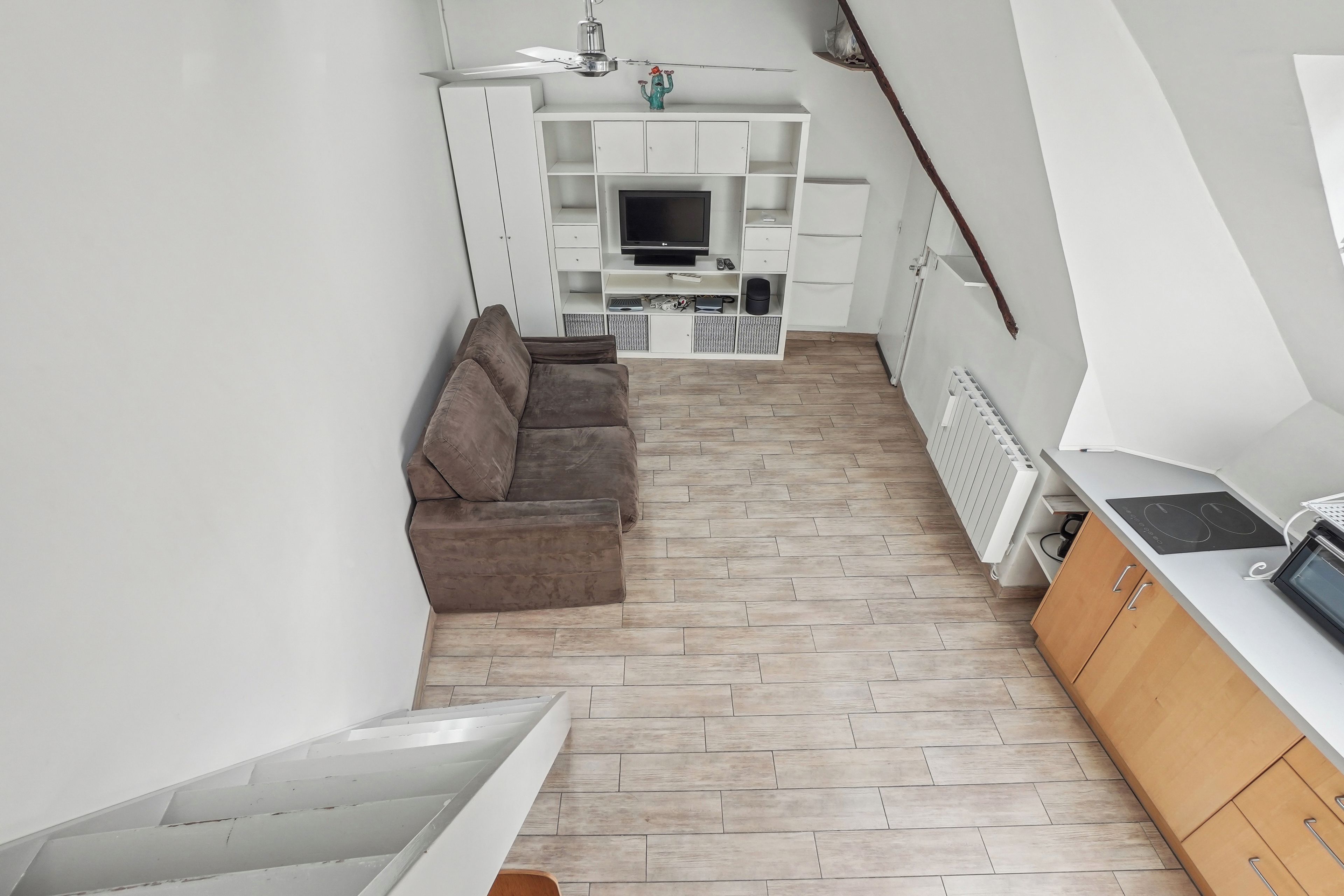 Een knus woongedeelte met een bank, een televisie en een kitchenette.