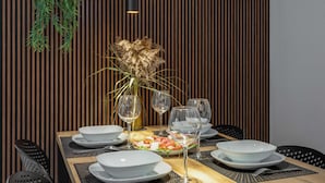 Une table à manger dressée avec des assiettes, des verres et un centre de table.