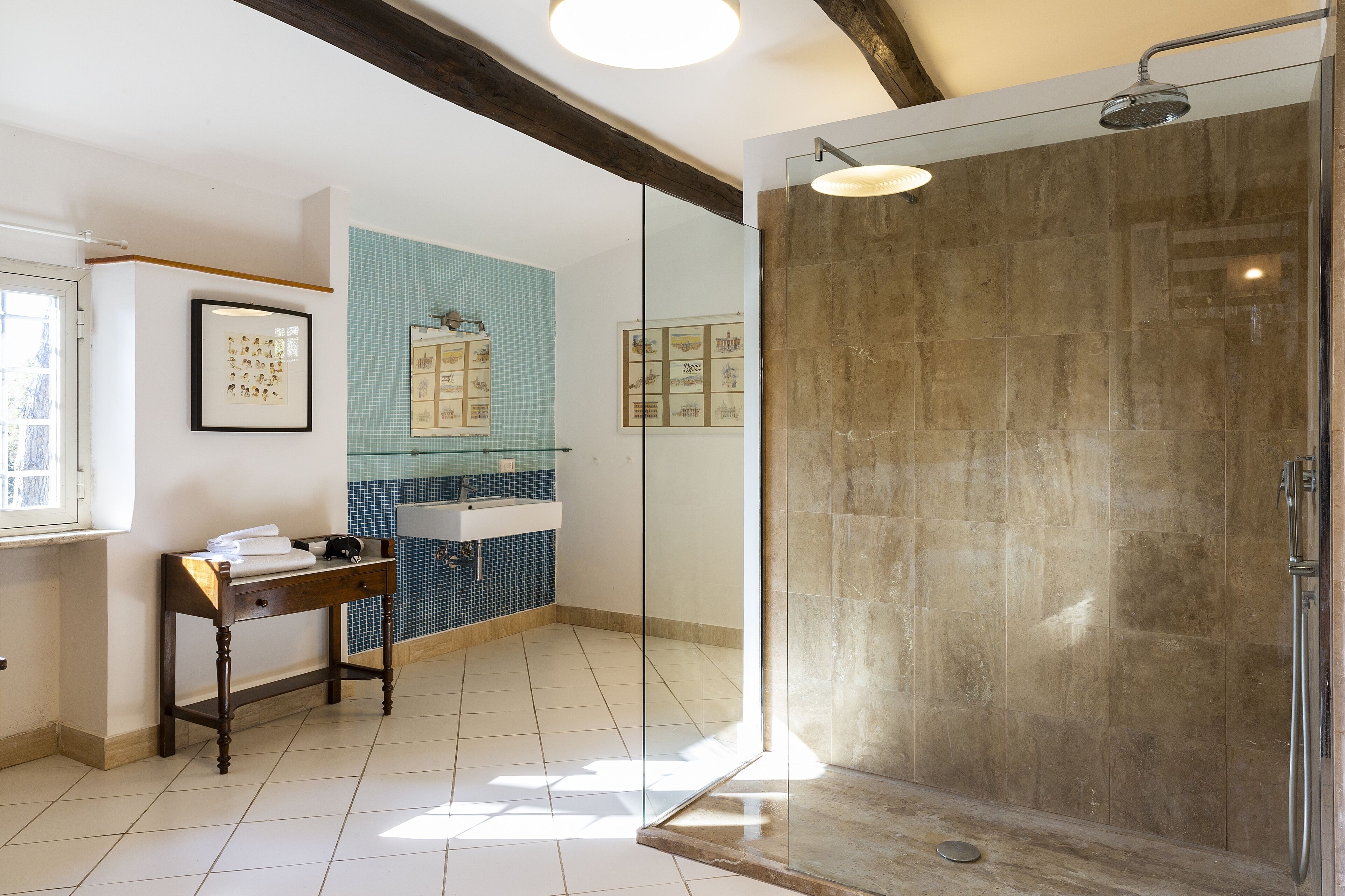 Un bany modern amb dutxa de vidre, un lavabo amb rentapel i un salvasalses retolat.