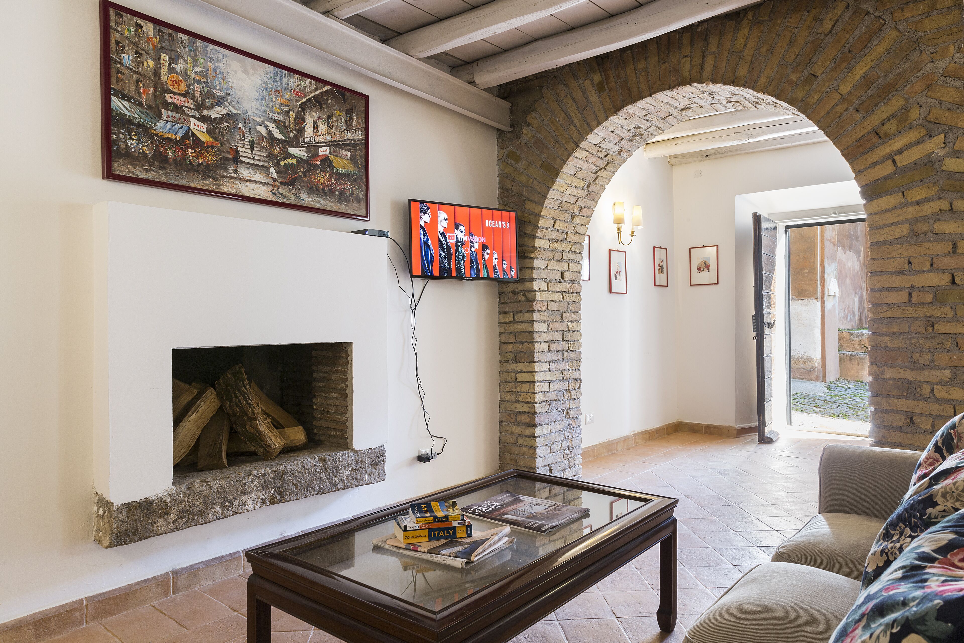 A living room with a fireplace, a television mounted on the wall, and a sofa.