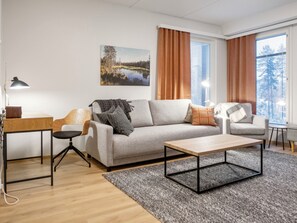Un salon moderne comprenant un canapé, une table basse, un bureau et une lampe.