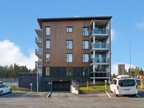 A multi-story residential building with a modern design, featuring balconies and large windows.