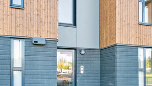 A modern building with wooden paneling and grey stonework.