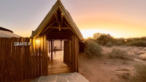Une structure en bois sur laquelle est apposée une enseigne indiquant « ZOO DES GIRAFES », et une lanterne suspendue au-dessus de l’entrée.