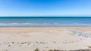 Ein Strand mit blauem Himmel und ruhiger See.