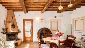 Una habitación acogedora con chimenea, muebles de madera y una mesa de comedor.