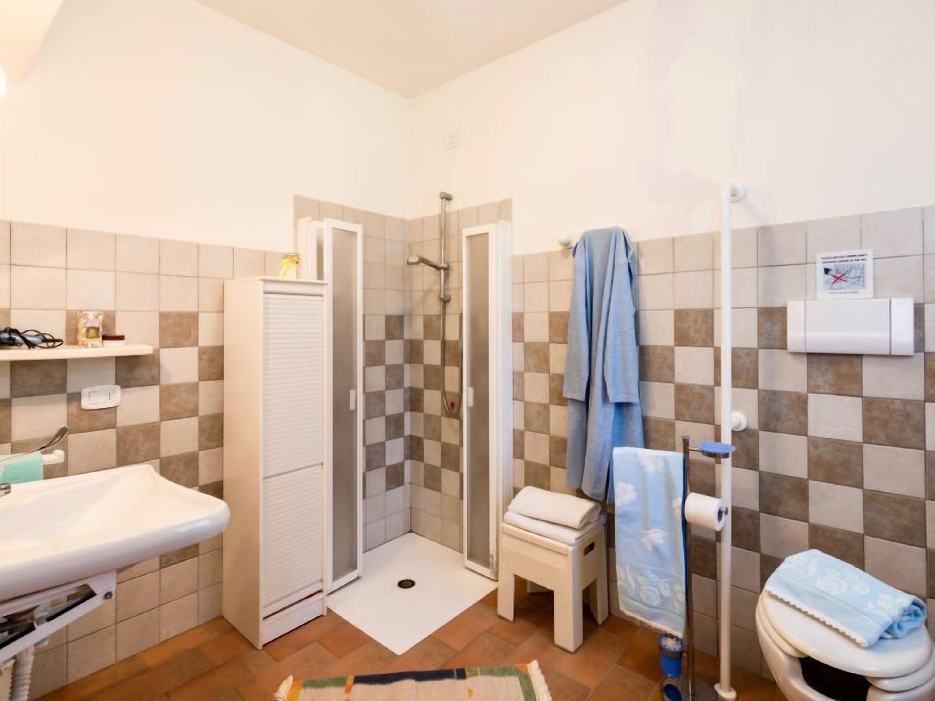 A bathroom with a shower, toilet, and sink.