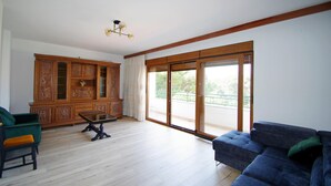Un salon spacieux avec un meuble en bois, un canapé bleu et un plancher en bois.