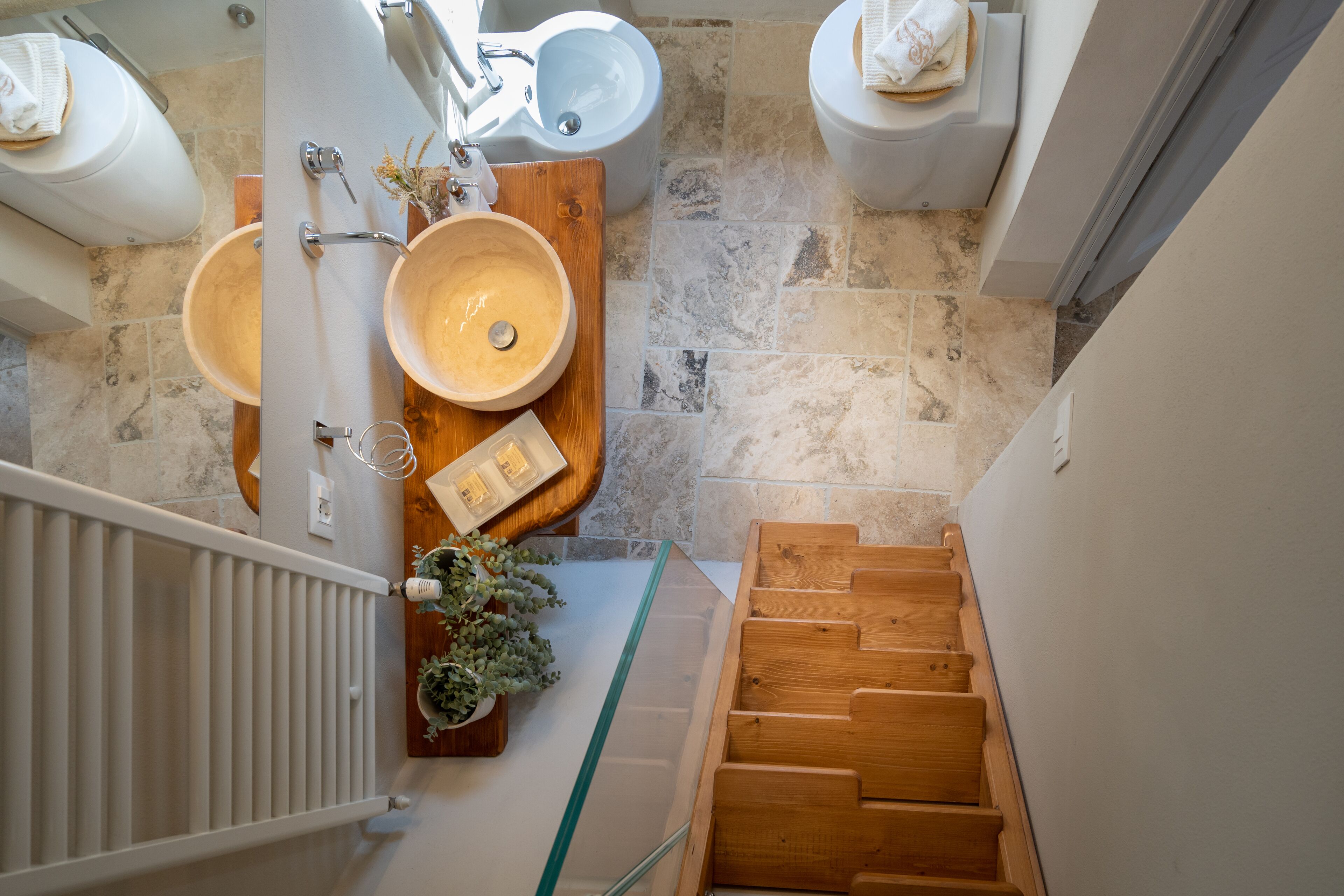 Une salle de bain avec deux lavabos, un meuble-lavabo en bois et une cabine de douche en verre.