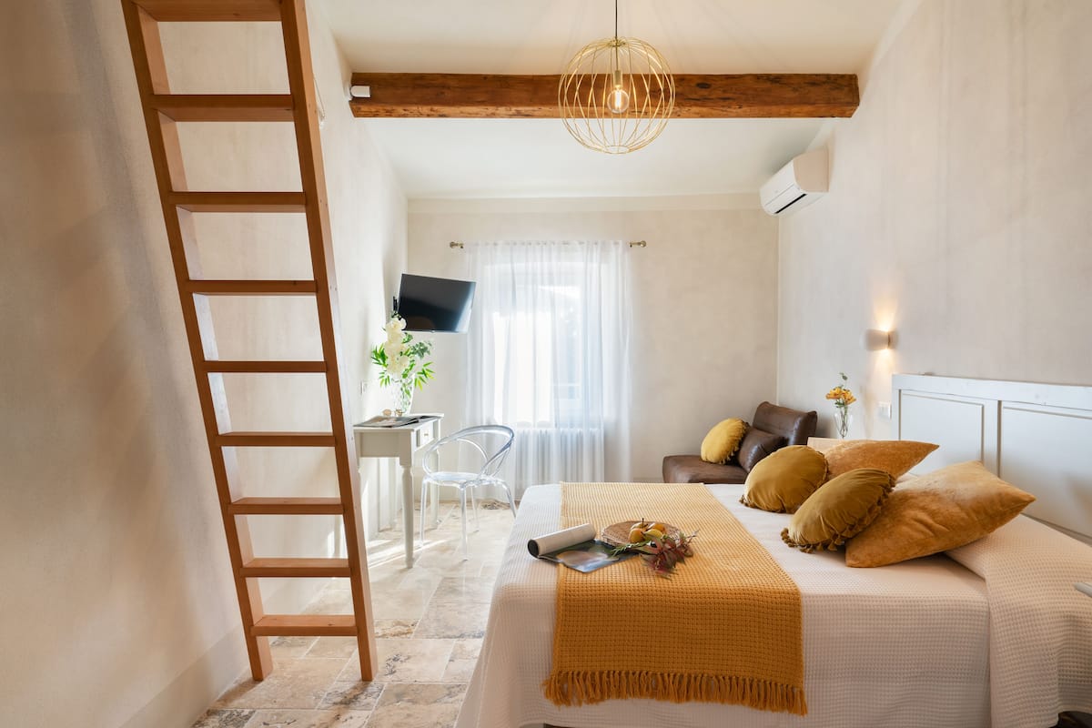 Un dormitorio con cama, escritorio, silla y televisor.
