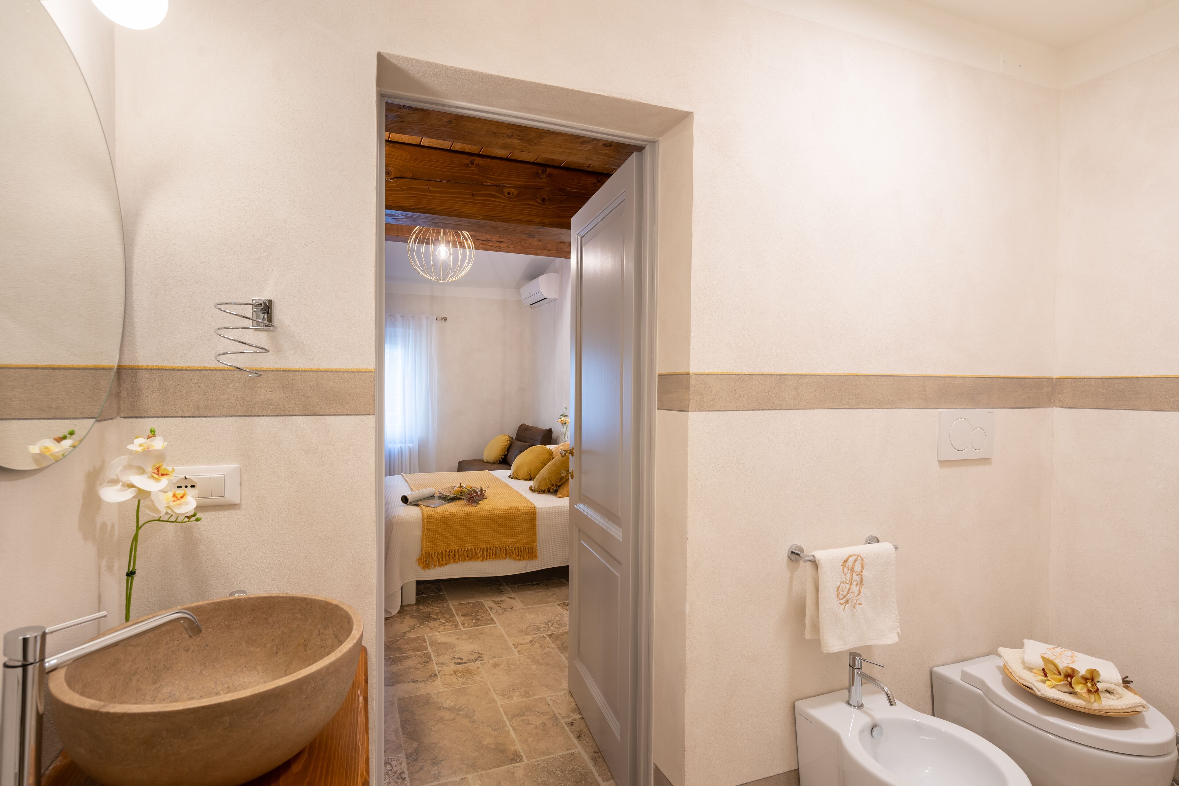 Une salle de bain avec un grand lavabo en pierre, un évier blanc et des toilettes.
