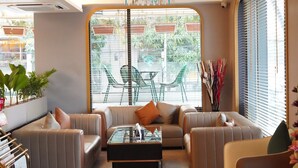 Un salón moderno con sofás de cuero, una mesa de centro de vidrio y vistas a través de un ventanal amplio.