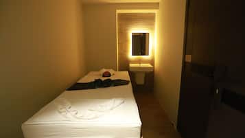 Simple, stylish accommodations with a single bed and compact bathroom.