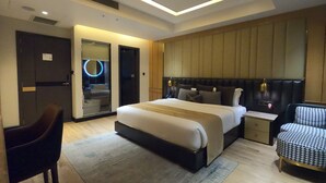 Una habitación de hotel moderna con una cama grande, mesitas de noche, un escritorio y una silla.