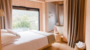 Une chambre avec un grand lit, une fenêtre et un plancher en bois.