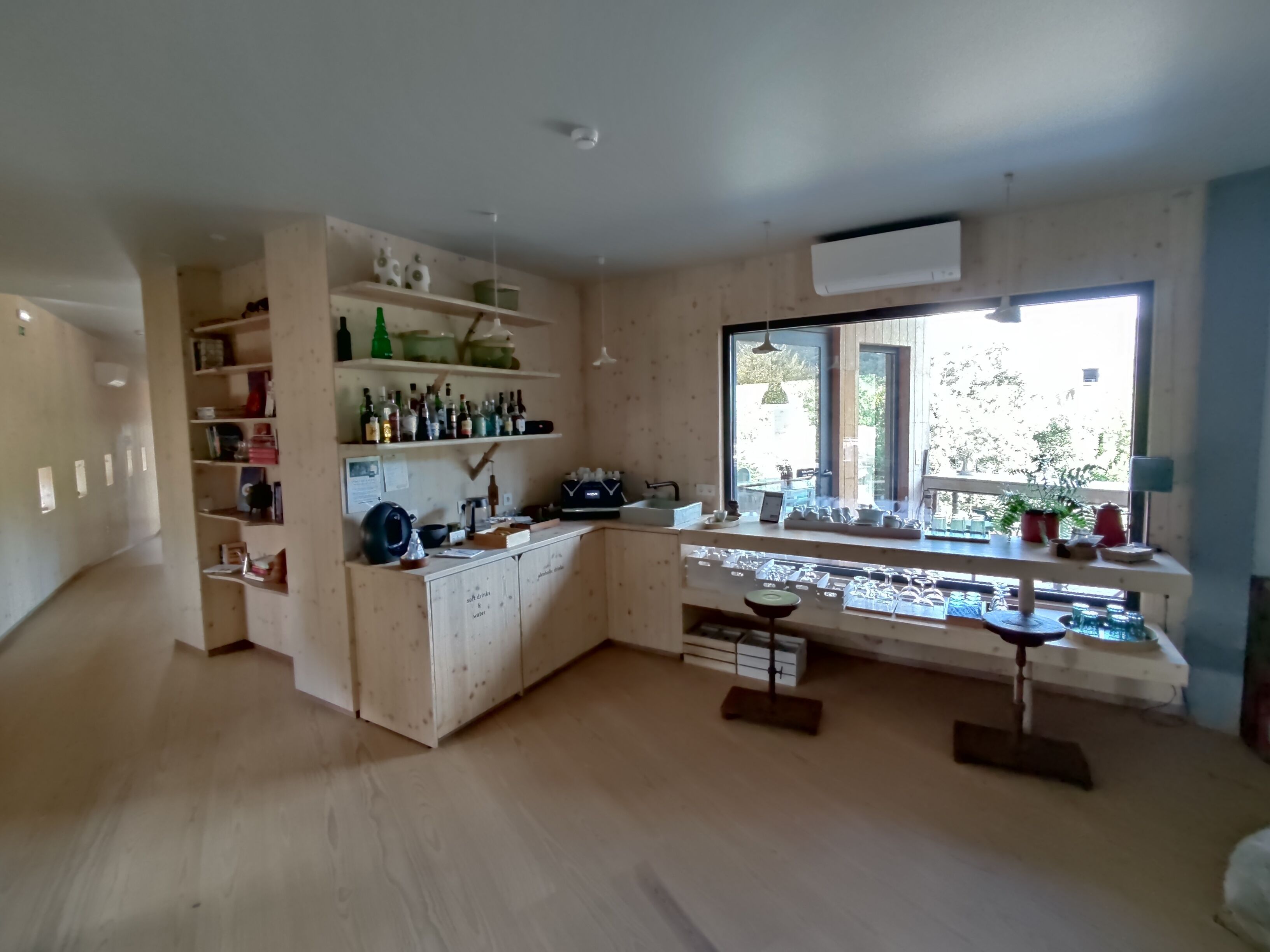 A spacious kitchen with wooden cabinets, a built-in wine rack, and a large window providing natural light.