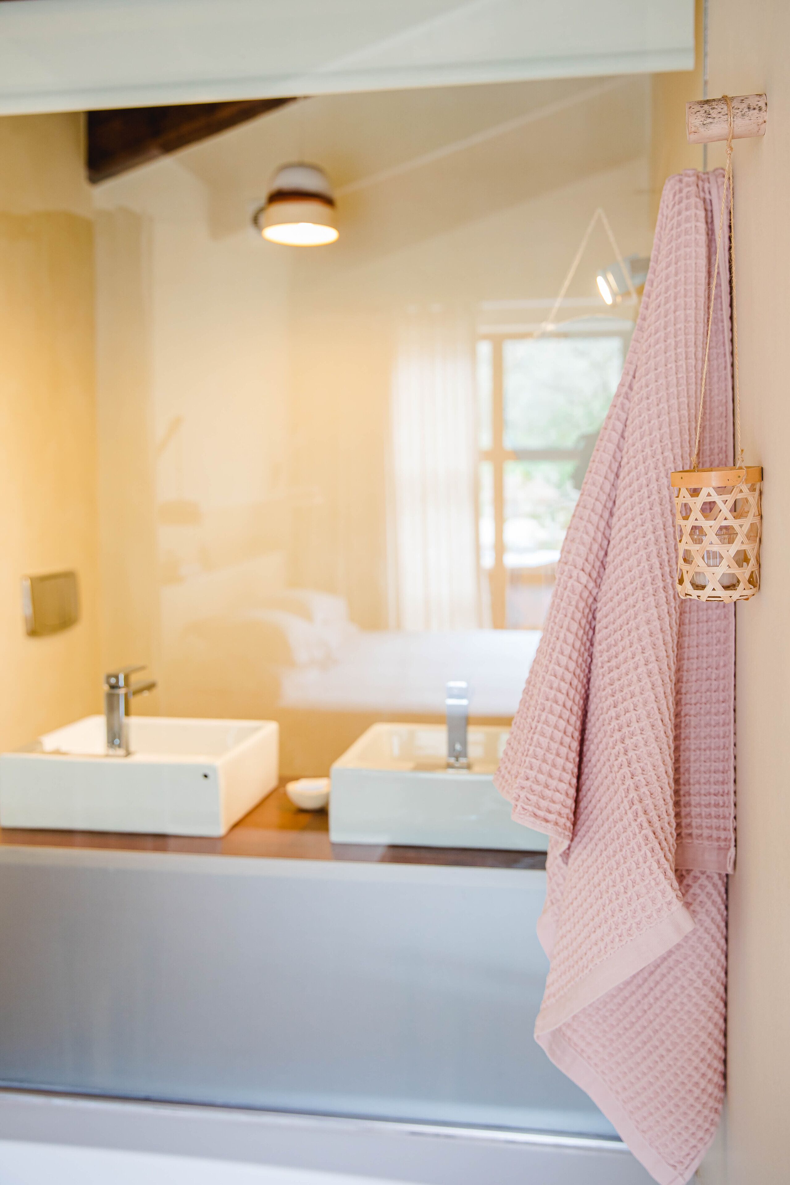A bathroom with two sinks, a mirror, and a towel hanging on the wall.