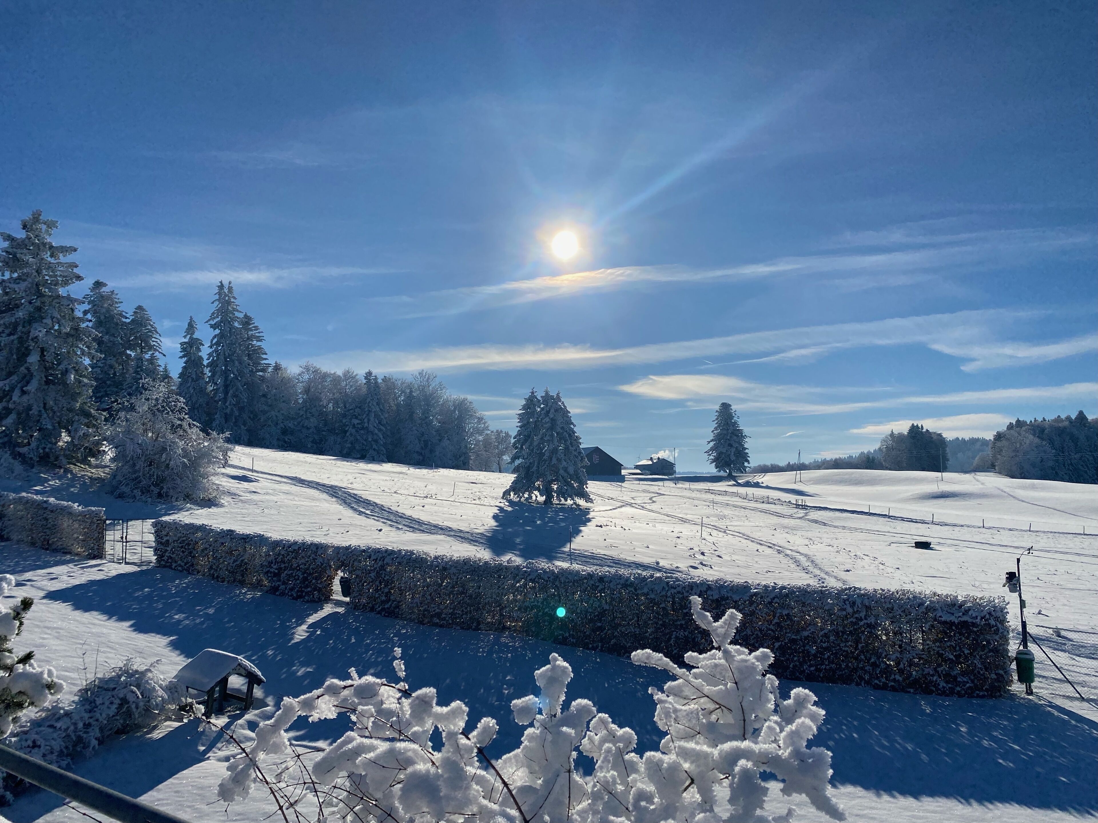 Eine verschneite Landschaft mit blauem Himmel und Sonnenschein.