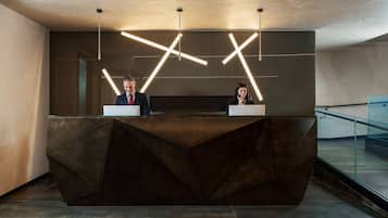 A reception desk with geometric lighting design and a modern, dark-toned reception area.