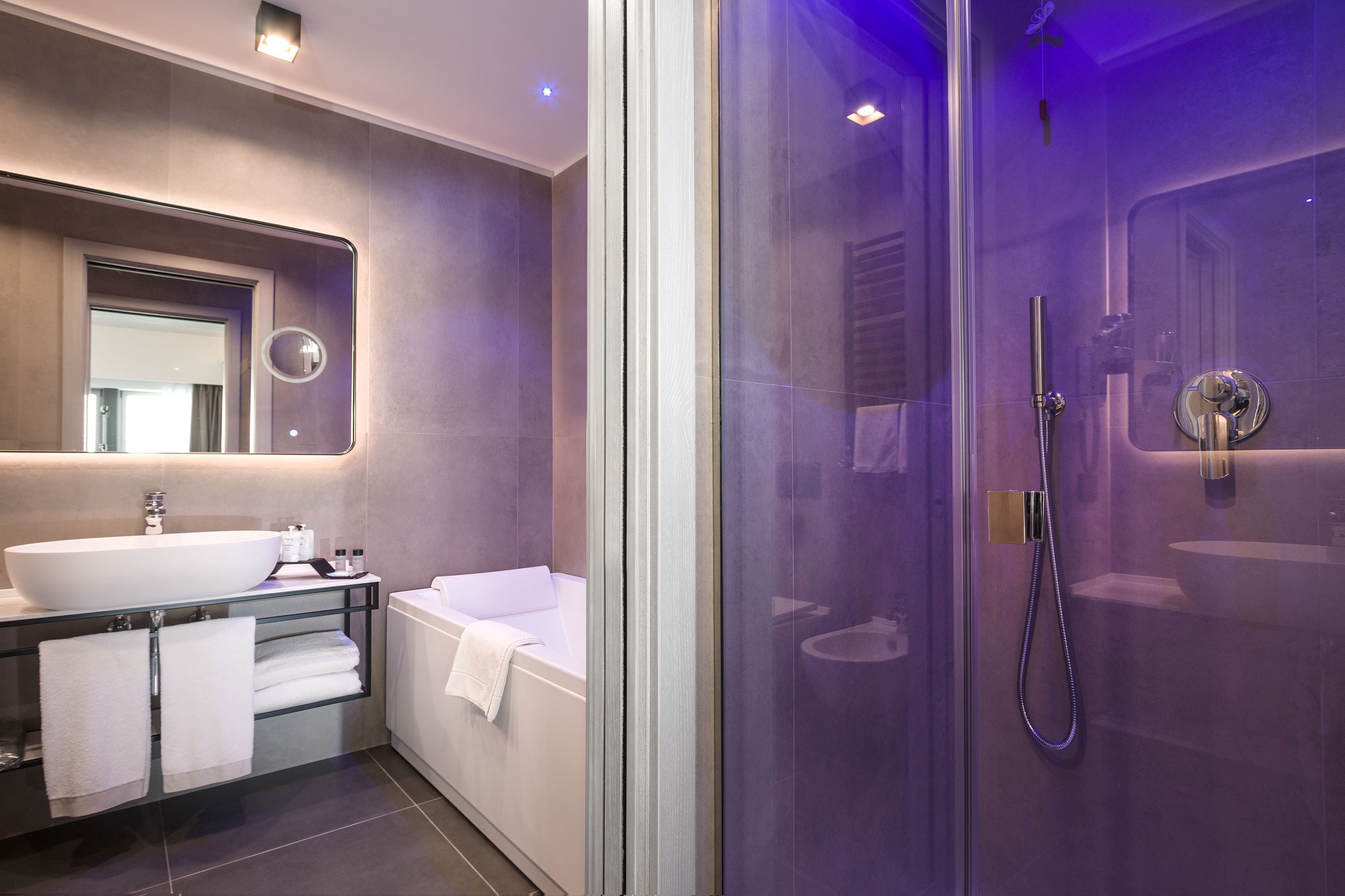 Un bagno moderno con doccia vetrata, un lavandino spazioso e una vasca da bagno.