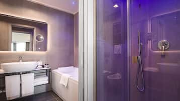 Un bagno moderno con doccia vetrata, un lavandino spazioso e una vasca da bagno.