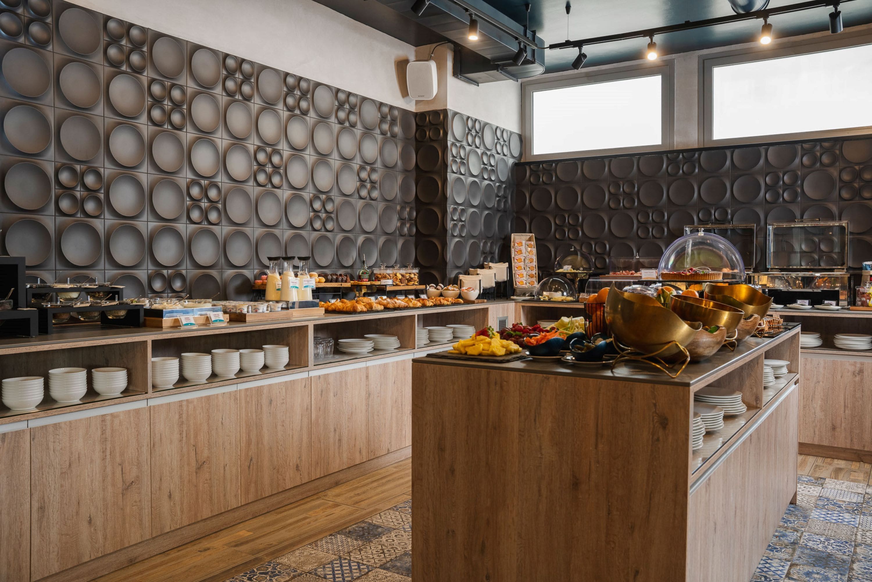 Ein reichhaltiges Buffet mit verschiedenen Speisen und einer Wand mit kreisförmigen Mustern.