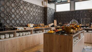 Ein reichhaltiges Buffet mit verschiedenen Speisen und einer Wand mit kreisförmigen Mustern.