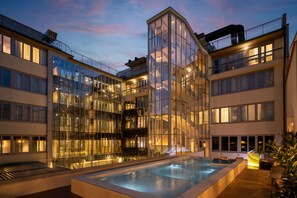 A modern hotel with a glass facade, a rooftop pool, and multiple balconies. - IQ Hotel Firenze (Florence)