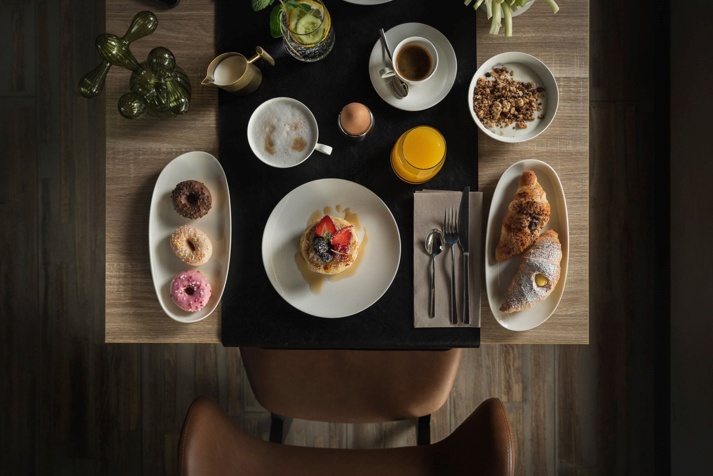 A breakfast table with various food items and drinks.