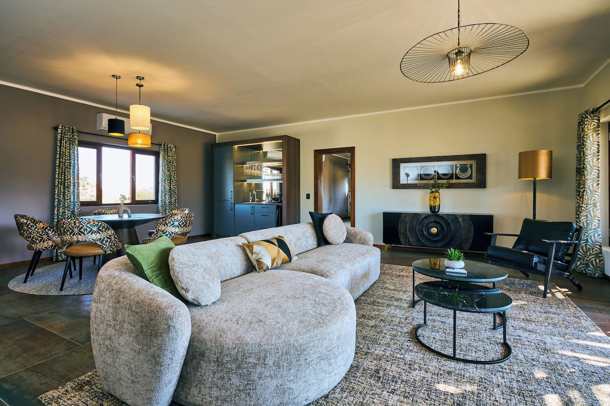 Una sala moderna con un sofá modular, una mesa de centro y un comedor con sillas.
