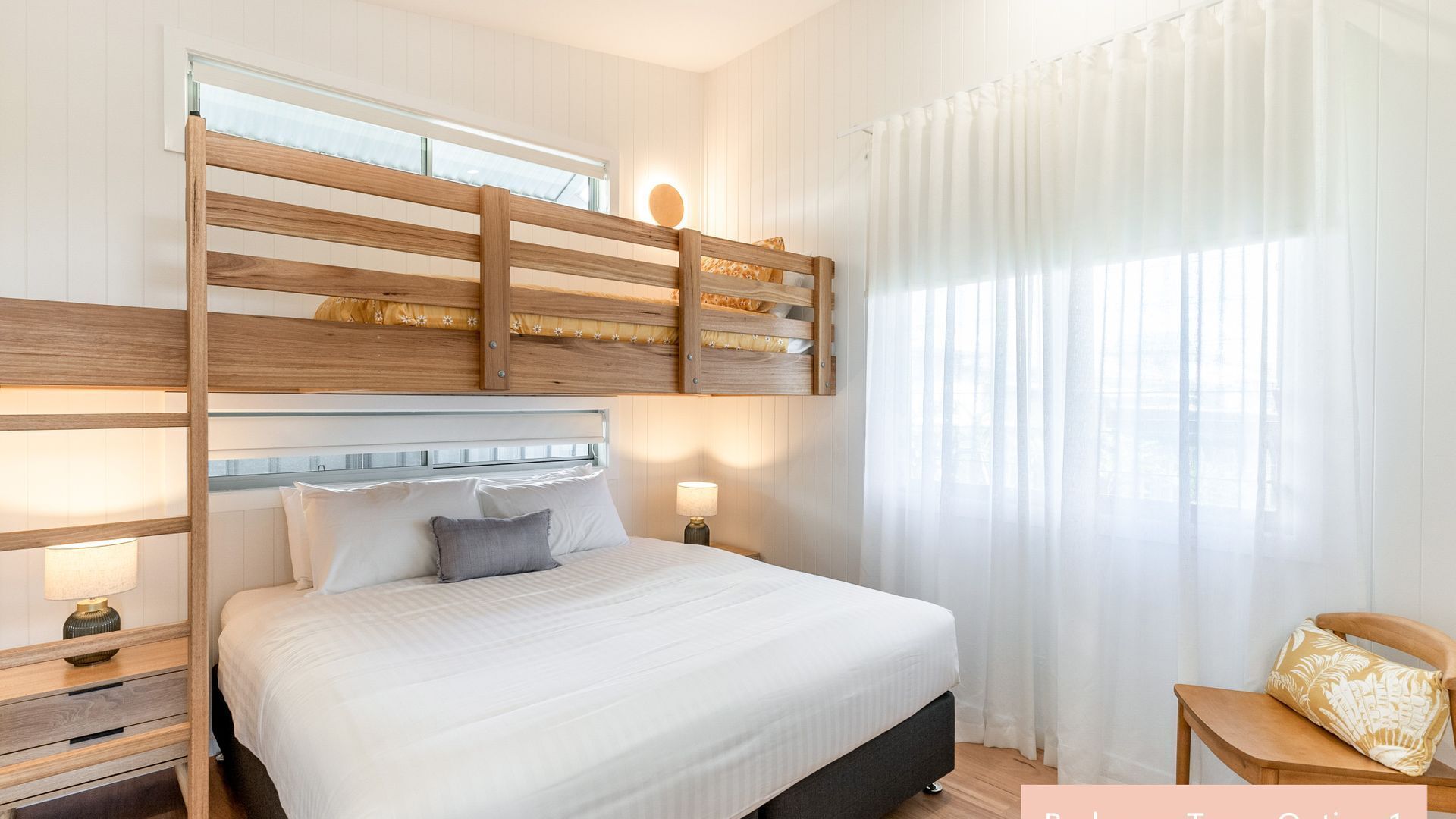 A bedroom with a bunk bed, a bedside table with a lamp, and a chair with a cushion.