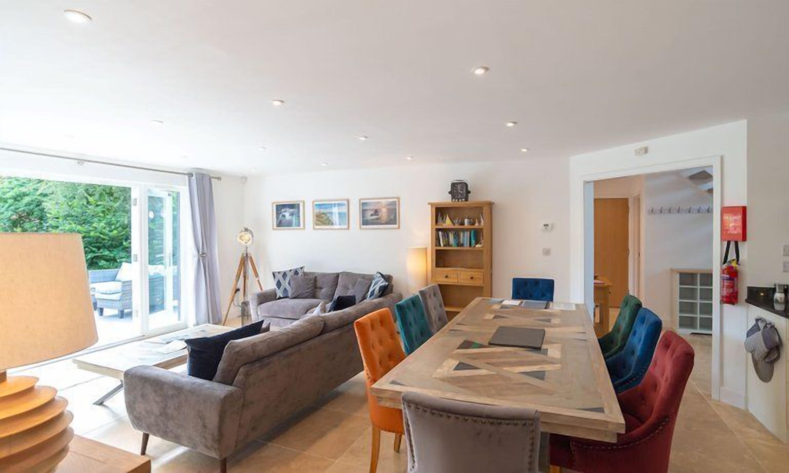 A modern living room with a sofa, a dining table, and a bookshelf.