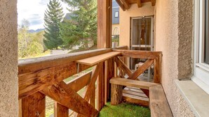 Eine Holzterrasse mit Blick auf einen Berg und Bäume.