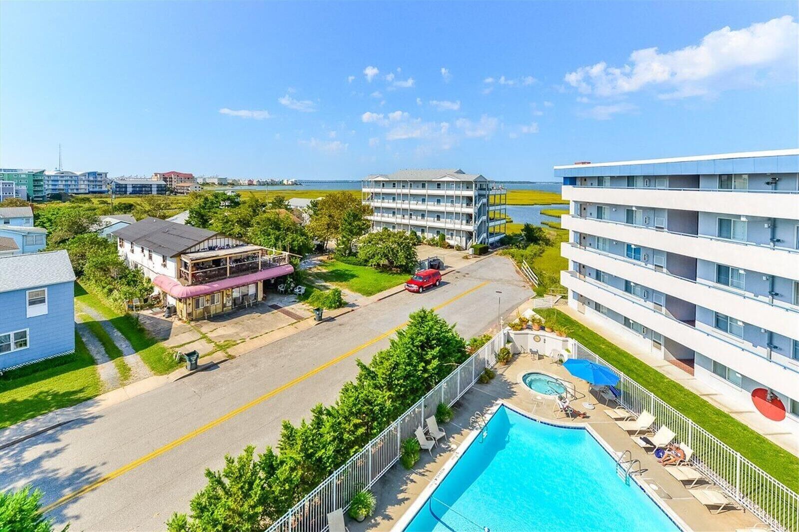 A hotel with a swimming pool, a street view, and a view of the ocean.