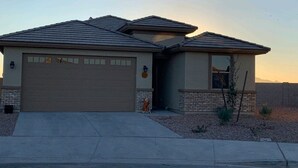 A single-story house with a garage, a small porch, and a brick foundation. - Lovely white & Grey home (Buckeye)
