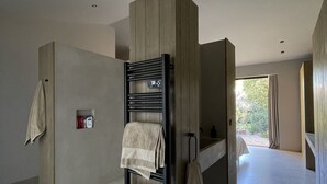Een moderne badkamer met een ingebouwde handdoekhouder, een douchegedeelte en uitzicht op de omgeving.