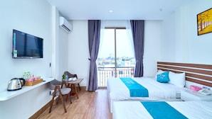 A modern hotel room with a large bed, a desk with a chair, a TV, and a balcony with a city view. - BOBO Boutique Hotel (Ho Chi Minh City)