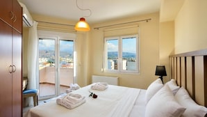 Ein Hotelzimmer mit Bett, Balkon und Blick auf die Stadt.