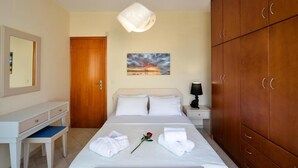 Ein Hotelzimmer mit Bett, Schreibtisch, Kleiderschrank und einem Bild an der Wand.