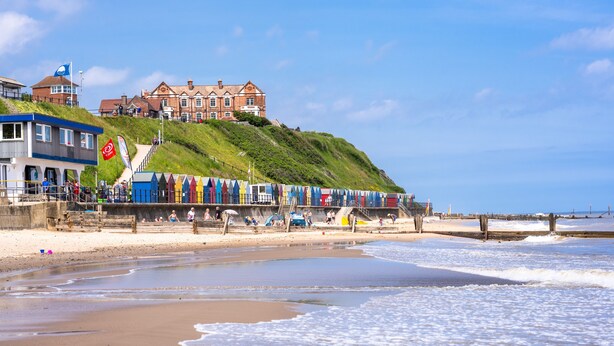 A coastal hotel with a beach view, a staircase leading to the upper levels, and a flag on the building. - The Stables, Edingthorpe, Norfolk (North Walsham)