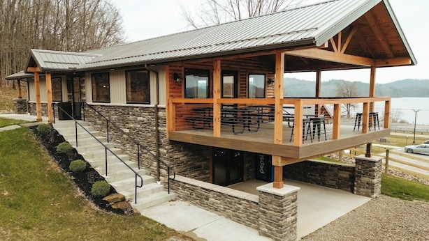 A lodge with a stone facade, wooden deck, and outdoor seating area.