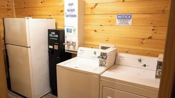 A laundry room with a refrigerator, a water dispenser, and a washing machine.