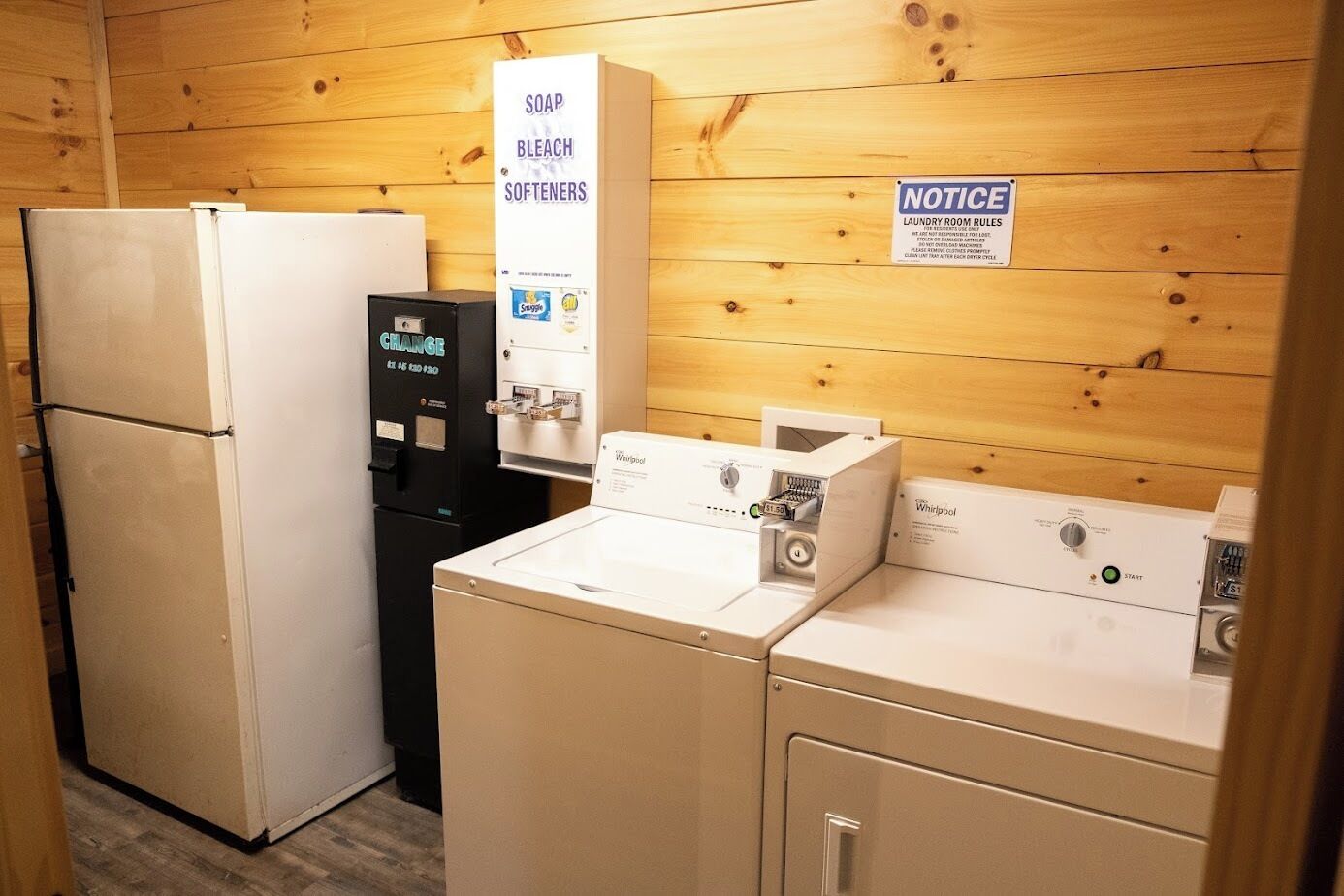 A laundry room with a refrigerator, a water dispenser, and a washing machine.