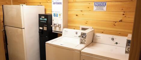 A laundry room with a refrigerator, a water dispenser, and a washing machine.