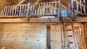 A rustic cabin interior with a lofted sleeping area, wooden walls, and a ladder to the upper level. - Yellowstone/Hot Tub-Pet friendly-Lakeview -8 Person Lodge (Scio)