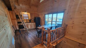 A wooden cabin interior with a kitchen, dining area, and a staircase. - Yellowstone/Hot Tub-Pet friendly-Lakeview -8 Person Lodge (Scio)