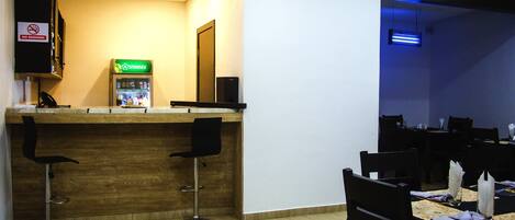 A restaurant with a wooden counter, two black bar stools, and a 'No Smoking' sign.